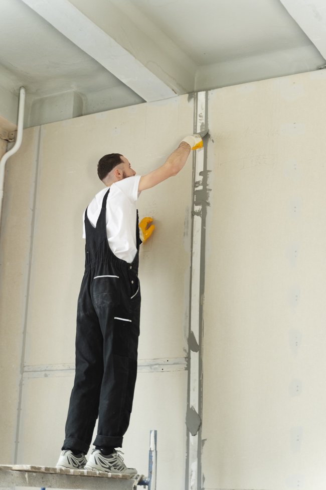 trabajador instalando pladur en la pared